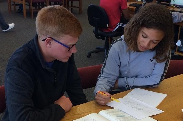 Michaela Trobough assists Wesley Leach with a math problem in the Academic Support area of the Allen Library. 
