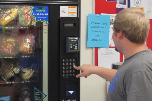A student makes a selection from a vending machine in the commons area of Allen Community Colleges Burlingame Campus.