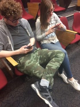 Freshman Austin Wickwire and Paige Durand scroll through their social media profiles while in the Allen Theater.