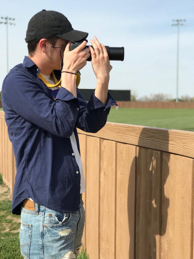 Student Life photographer Chase Hochard takes a photo of the Red Devil soccer team