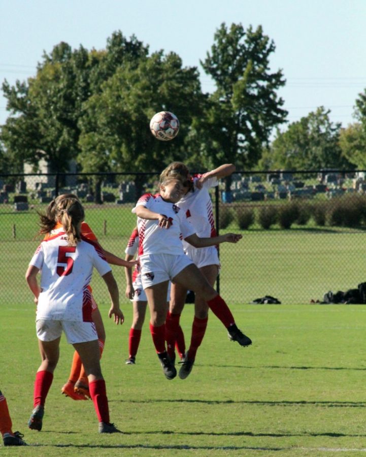 Members on the women’s soccer team jump to keep control of the ball.
