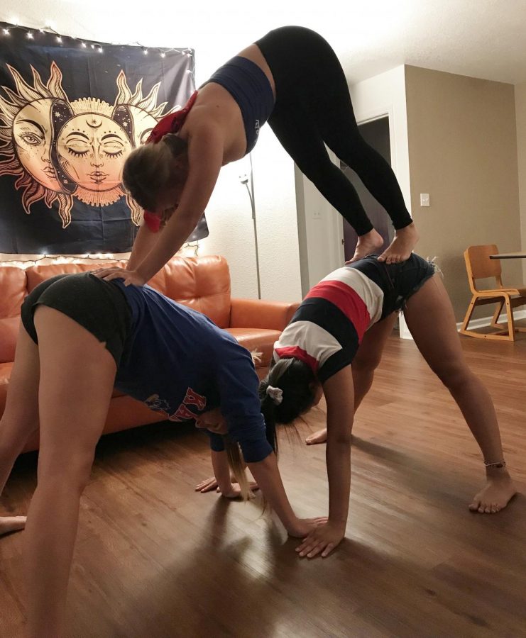 My roommates and I form a three-person pyramid yoga pose. 