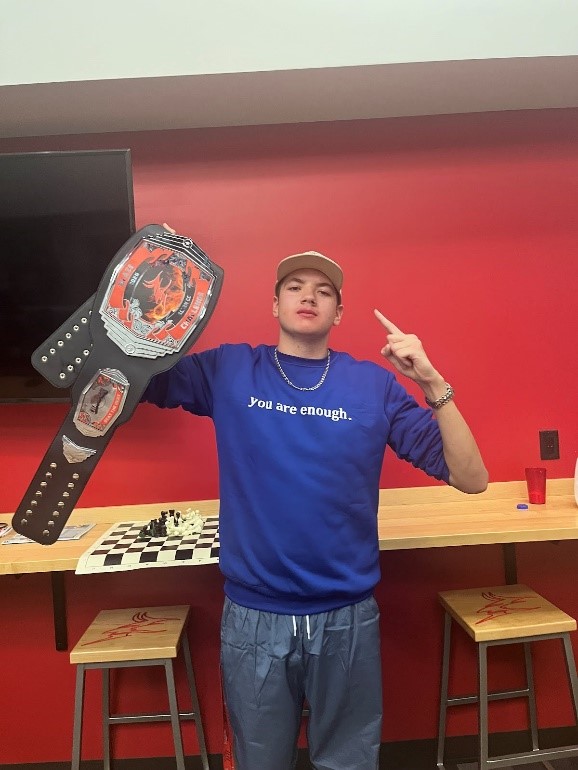 Casey Rowe holds up the Blaze Champion belt in celebration of his victory. 